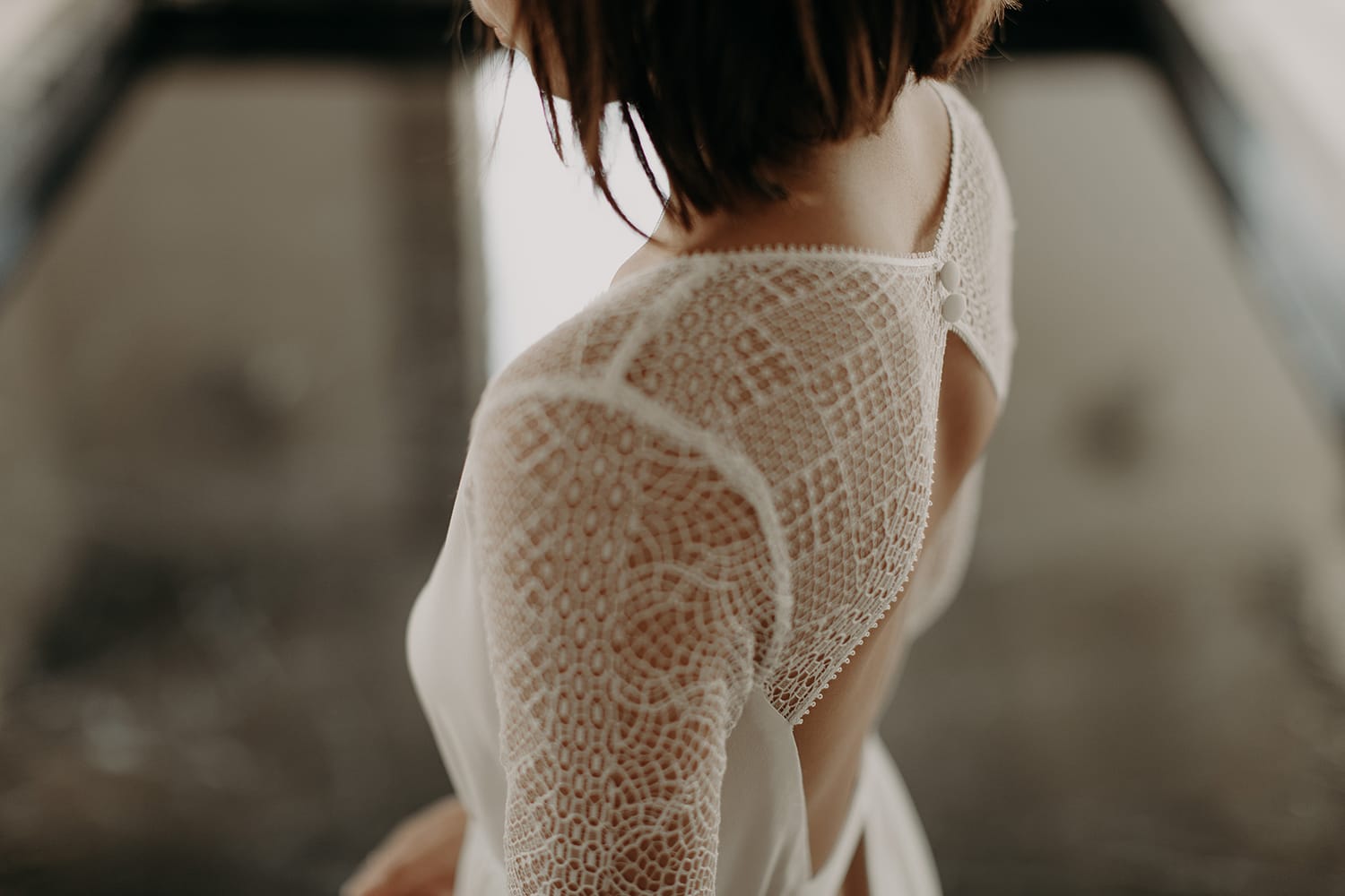 Détail de la robe de mariée Camille Marguet Angèle, manche en tulle brodé géométrique et dos boutonné